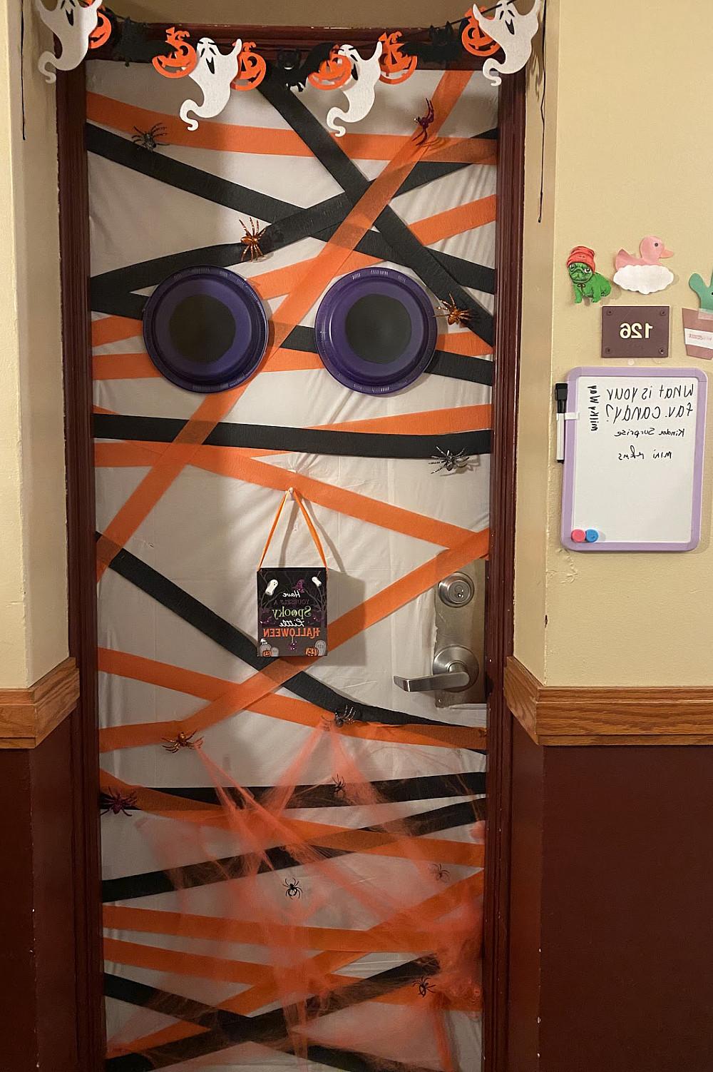 宿舍的门上挂着橙色和黑色的丝带，还有两只紫色的眼睛.